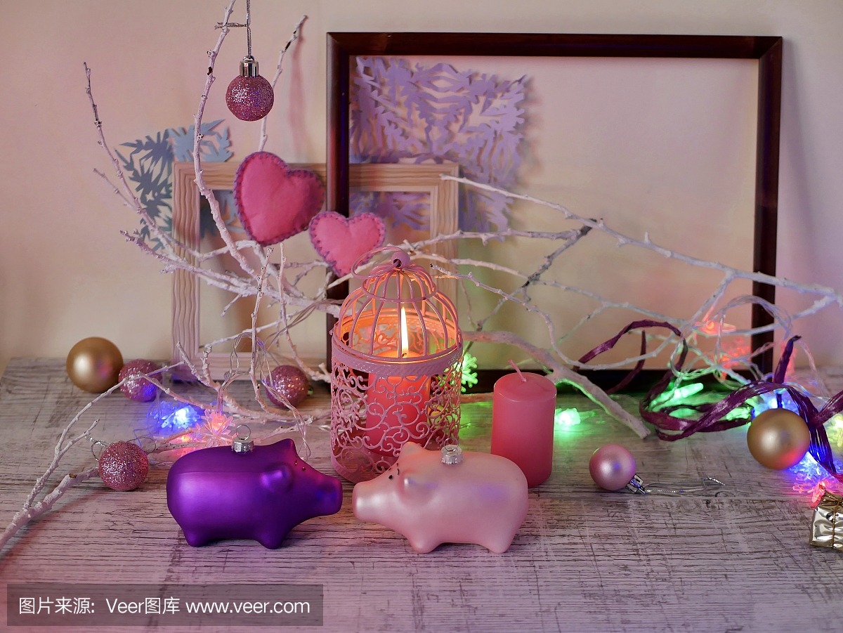装饰组成一对圣诞装饰猪,燃烧的蜡烛,节日灯饰,感觉心,球对空木制框架